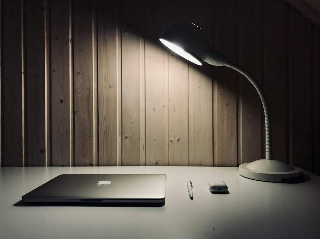 Open notebook and warm desk lamp light in a quiet studio