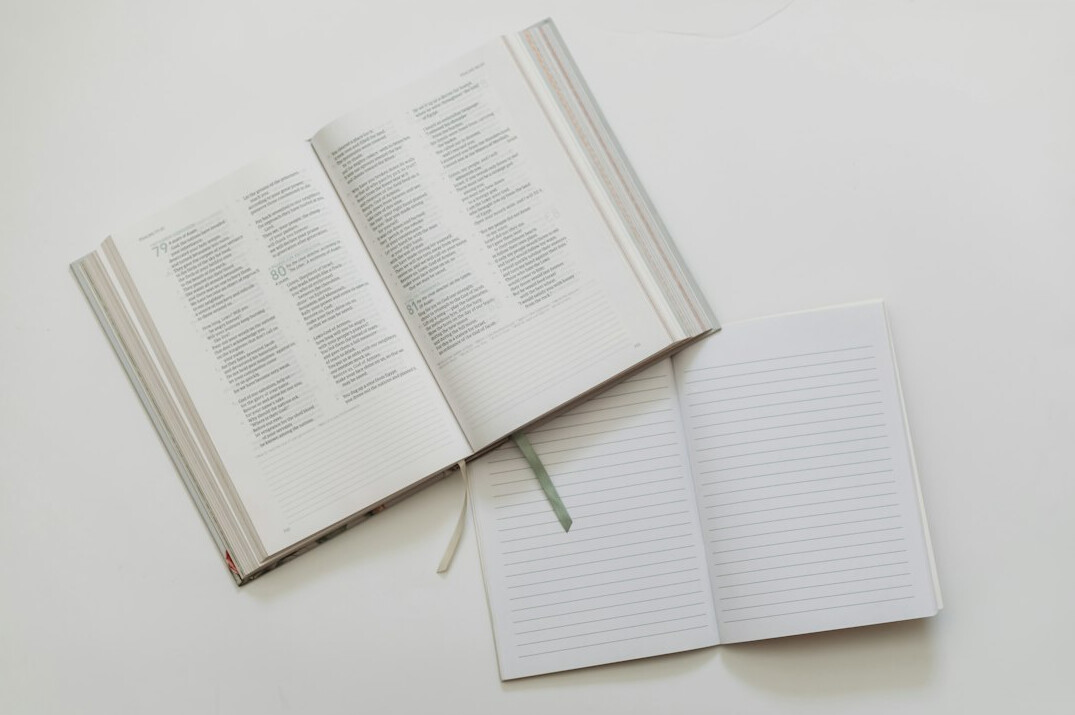 Open notebook with handwritten voice exercise notes and a pen